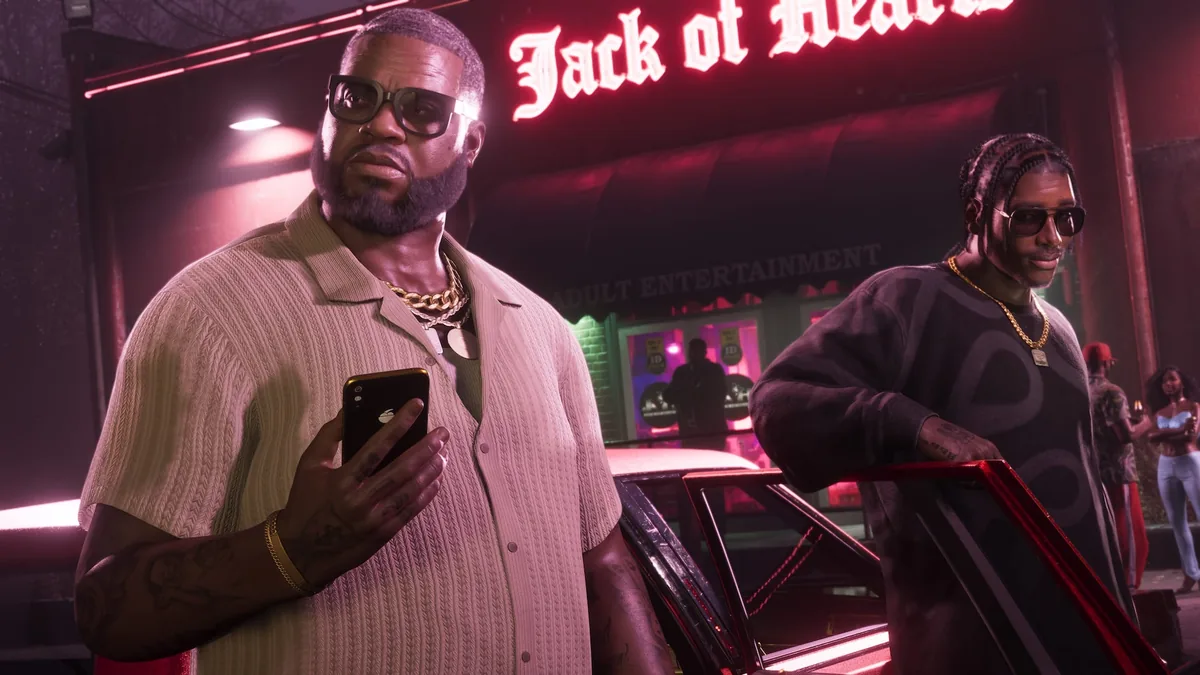 Boobie Ike checking his phone outside the Jack of Hearts strip club at night, Dre'Quan Priest by a car behind him, official GTA 6 screenshot