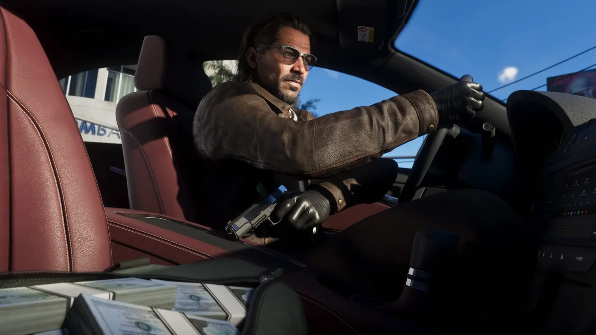 Raul Bautista driving in leather gloves with a pistol in hand and bricks of cash on the passenger seat, official GTA 6 screenshot